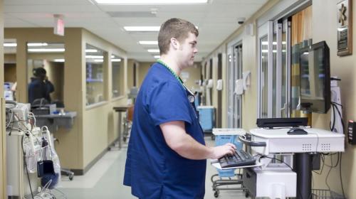 emergency department doctor looking at information on a computer